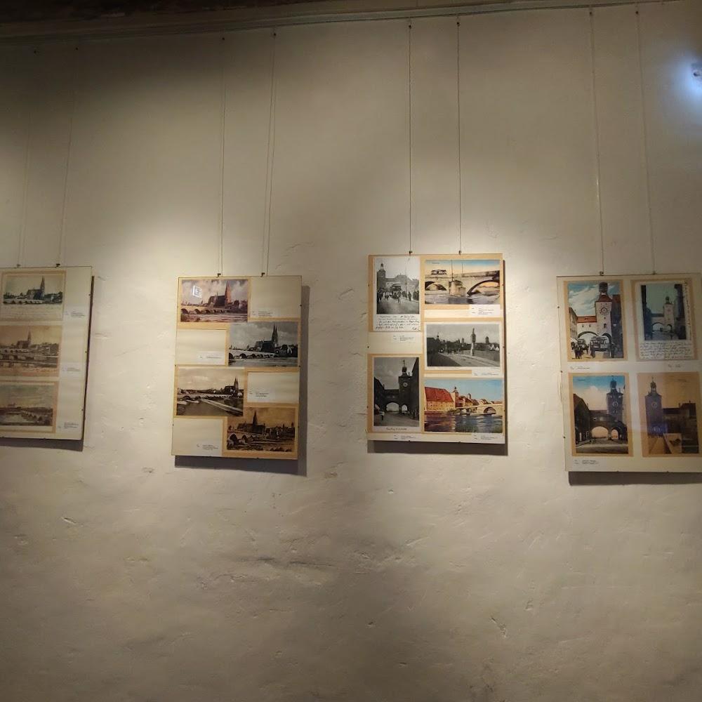 Four framed pictures of bridges and cityscapes.  The pictures are hanging on a wall.  The landmark is the Charles Bridge in Prague.